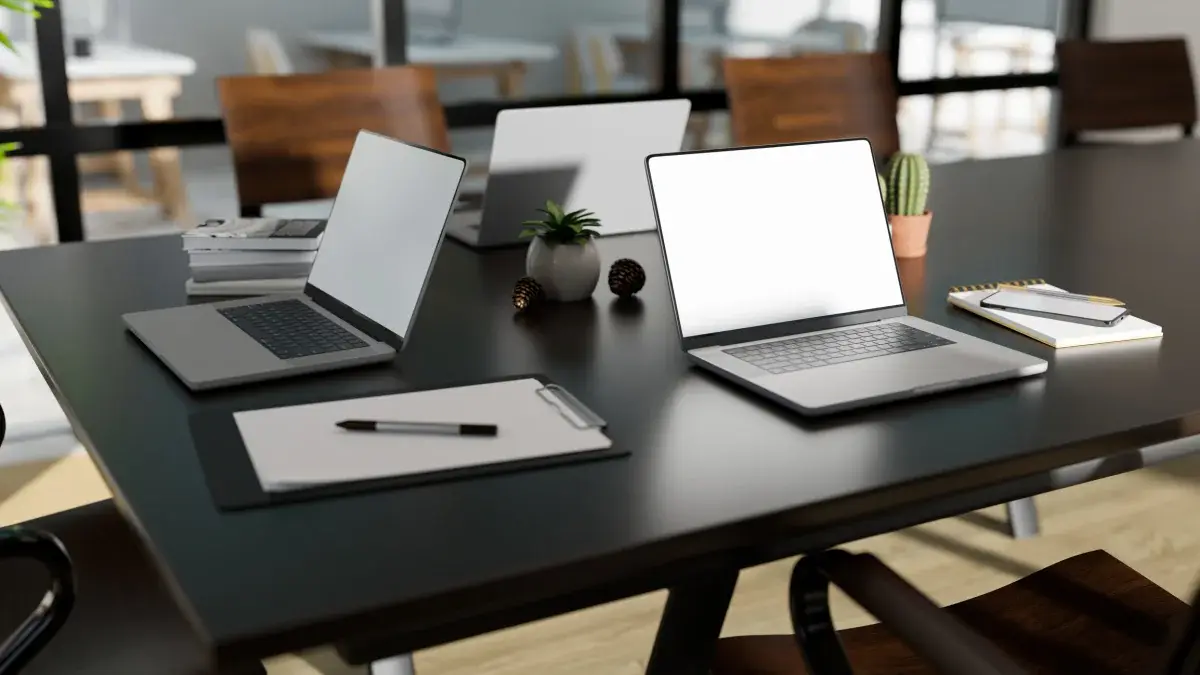 Laptops open on desks in a modern shared workspace
