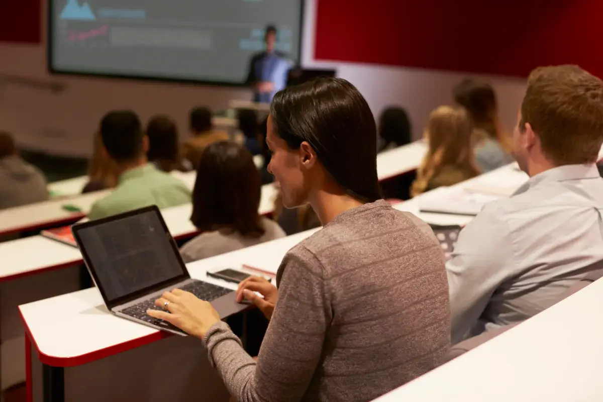 Students taking notes on laptops during a lecture