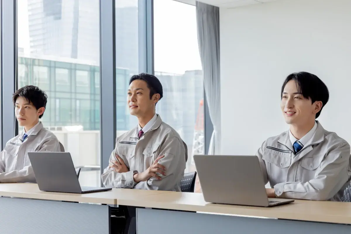Team members seated in a row using matching silver laptops