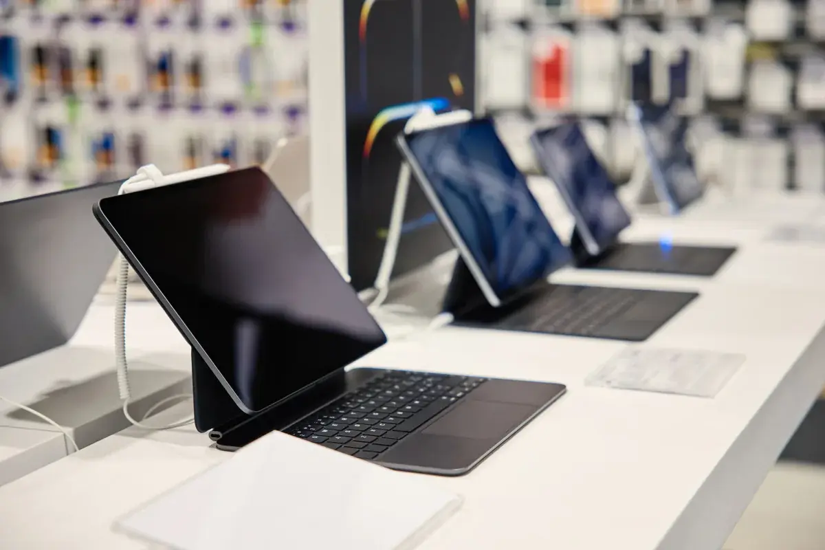 Several 2-in-1 tablet laptops with keyboards lined up on a counter