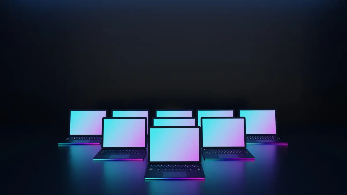 Row of high-performance laptops with glowing screens staged for a demo