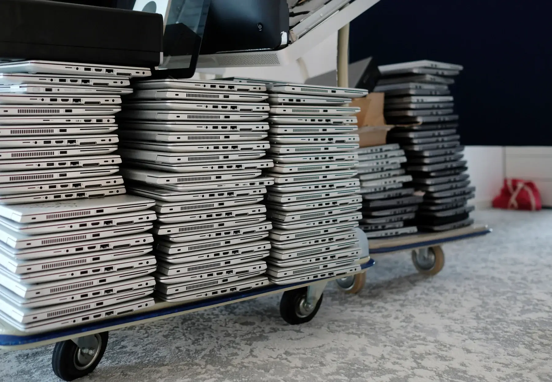 Stacks of rental laptops on a cart, prepared for a large deployment