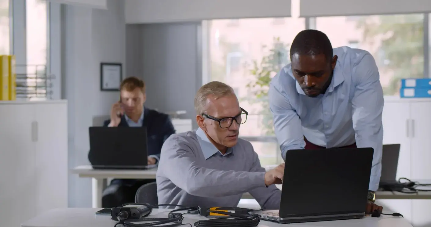 IT staff helping a user with a new application on a laptop